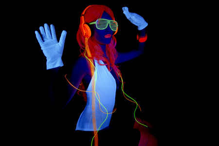 sexy female disco dancer poses in UV costume