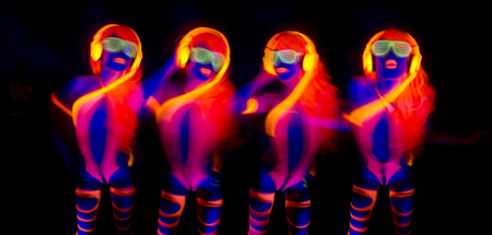sexy female disco dancer poses in UV costumeの写真素材
