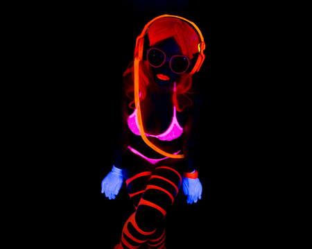sexy female disco dancer poses in UV costumeの写真素材