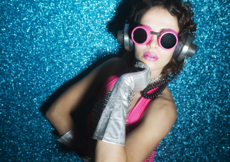 sexy disco dancer in pink bikini against blue backgroundの写真素材