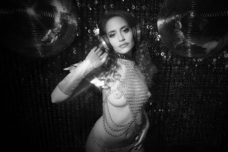 sexy disco party woman dressed in a unique silver costume with metal wings. Perfect for stylish club, disco and fashion eventsの写真素材