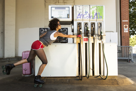 a cool roller skating woman dances and skates outside in an urban settingの写真素材