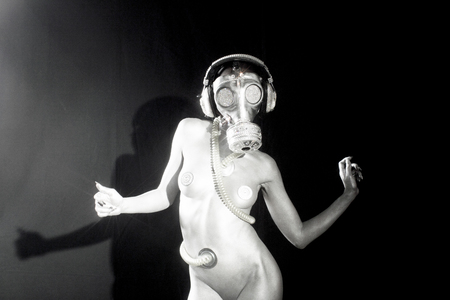 sexy woman dances in silver body paint with a gas mask covered in sparkling crystals. how to survive the apocalypse in bling bling styleの写真素材