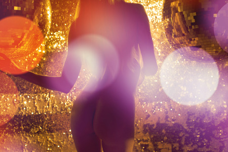 amazing sexy woman dances in a sparkling gold costumeの写真素材