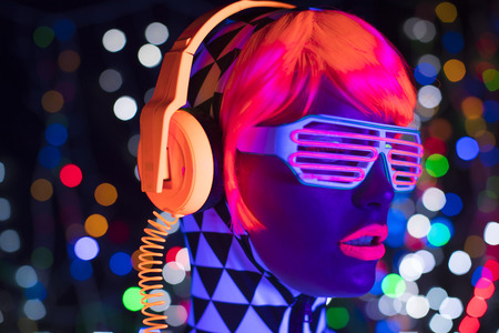 fantastic video of sexy cyber raver woman filmed in fluorescent clothing under UV black lightの写真素材
