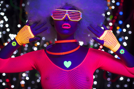 fantastic video of sexy cyber raver woman filmed in fluorescent clothing under UV black lightの写真素材