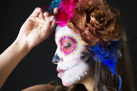 beautiful woman with custom designed candy skull mexican day of the dead face make up