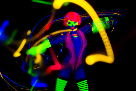 sexy female disco dancer poses in UV fluorescent costumeの写真素材