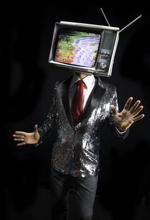 smart suited perfromer with a television as a head. the tv has distortion and static on it