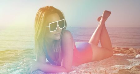 beautiful woman in rainbow bikini sunbathing and posing in barcelona on a summers morningの写真素材