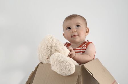 adorable small baby girl in a box with cuddly teddy bearsの写真素材