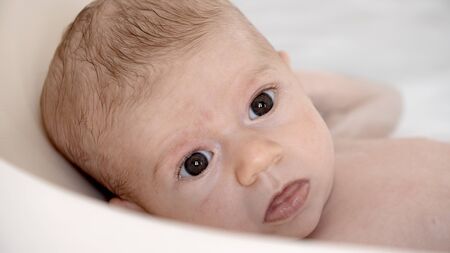 cute newborn baby girl enjoying bath time