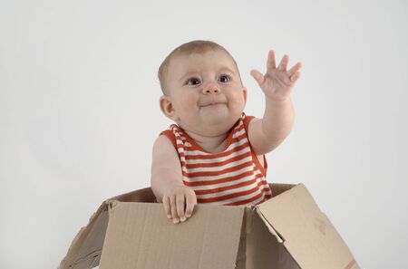adorable small baby girl in a cardboard boxの写真素材