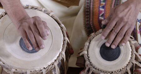 close-up of the hands of an Indian musician drumming on traditional tabla percussion instrument