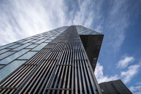 Clouds passing over glass skyscraperの写真素材