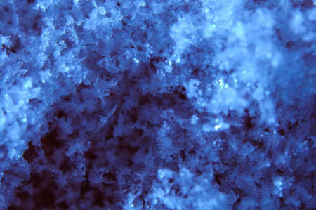 Snow with snowflakes shapes on blue surfaceの写真素材