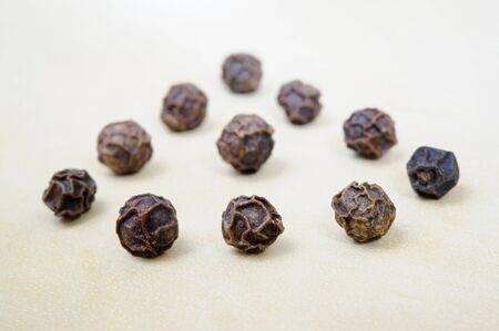 Black peppercorns details on light horizontal deskの写真素材