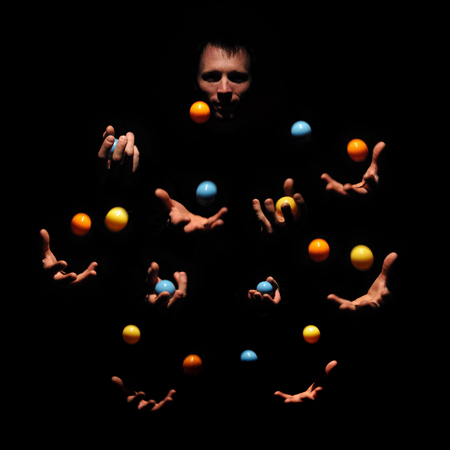 Talented man juggling with color balls. Successful concept. Caucasian performer show exhibition.の写真素材