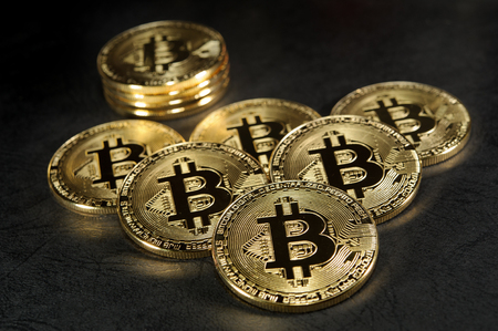 Luxury pack of golden bitcoins on dark leatherの写真素材