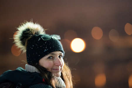 White woman with knit hat and glasses on hat, looking and smilign to the camera. Happy and joyful winter mood.の写真素材
