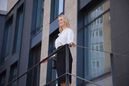 business woman standing in front of office buildingの写真素材