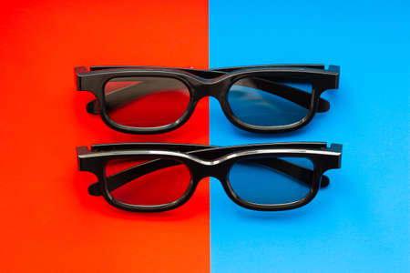 3D glasses for watching movies in the cinema and at home on a red-blue background close-up, two...