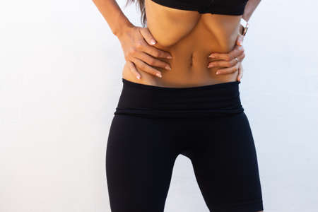 Young woman doing abdominal vacuum exercises on white background. Young pretty woman do breathing...