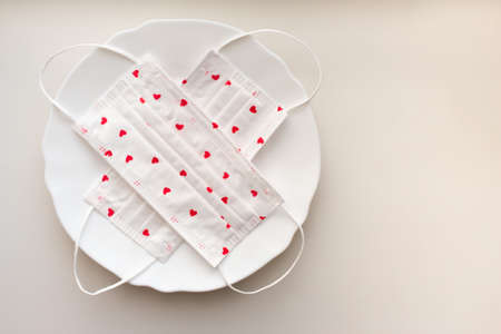 Valentine's Day during a pandemic and quarantine. Medical white protective masks with the image of...