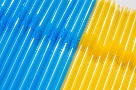 Plastic straws for cocktails in the colors of the Ukrainian flag. Blue and yellow cocktail tubes close-upの写真素材