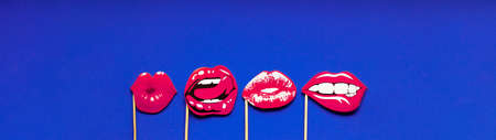 Different shapes of female lips, banner with place for text. Lip stencils on a purple empty background. Pink lips in the form of kisses. Concept of lip augmentation and cosmetology. Copy spaceの写真素材