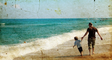 father and son playing together on the beach. Photo in old image style.の写真素材