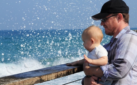 ather and his daughter walking on the beach on  sunny day