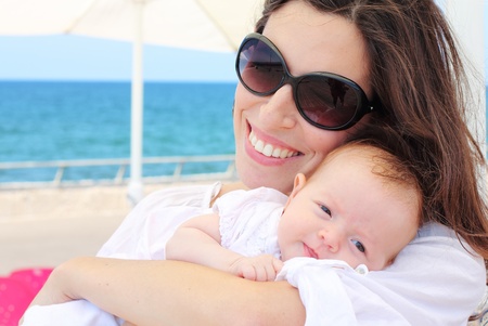 Young mother with her baby on the beachの写真素材