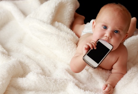 7-month-old beautiful child with blue eyes on a white blanketの写真素材