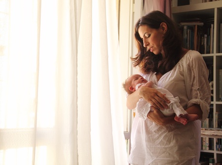 beautiful young mother is holding her newborn babyの写真素材