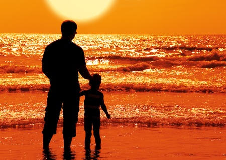silhouettes of father and son on sunset の写真素材