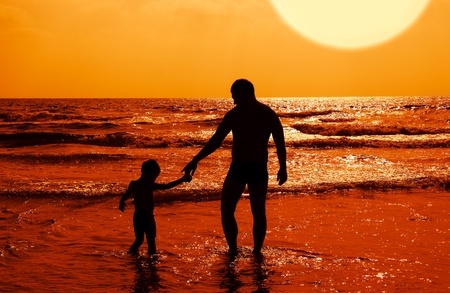 silhouettes of father and son on sunset の写真素材