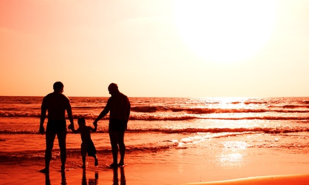 child with his father and grandfather watching sunsetの写真素材