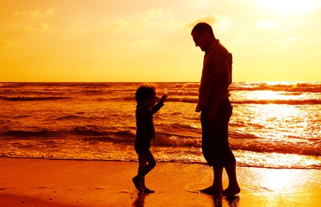 silhouettes of father and son on sunset の写真素材