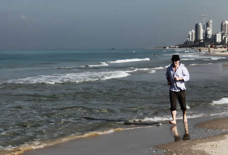 young smiling businessman celebrating on the beach の写真素材