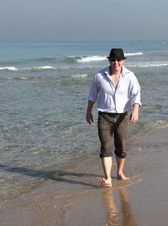 Handsome 30-year-old man in a hat at seaの写真素材