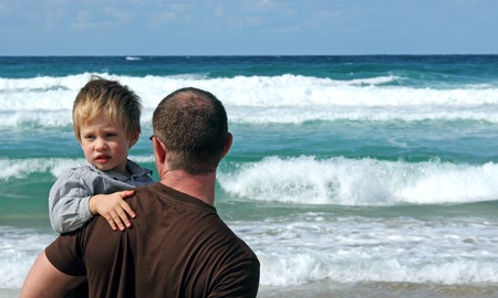father and son playing on a beach の写真素材
