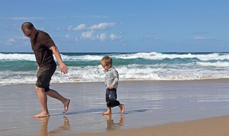 Father playing with his son at beach の写真素材