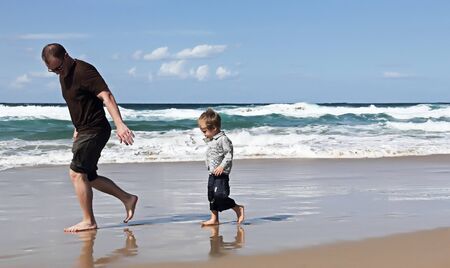 Father playing with his son at beach の写真素材