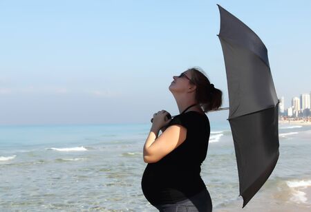 pregnant woman standing on the beach の写真素材