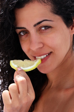 Young beautifull woman eating lemonの写真素材