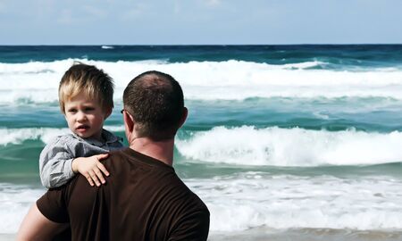 father and son playing on a beach の写真素材