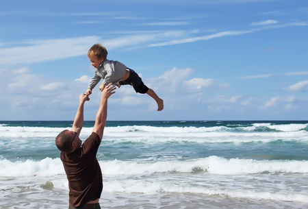 Happy father and son on the beachの写真素材