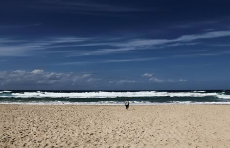 3-year-old looks at the sea. Autumn sea, strong waves, sharp colors.の写真素材