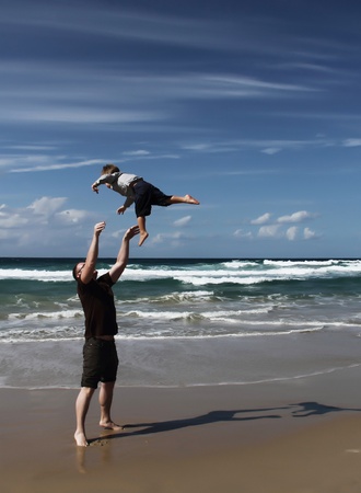 Dad and son playing on the sea  Autumn sea, strong waves, sharp colors の写真素材